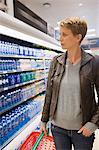 Femme, bouteille d'eau dans un magasin d'achat