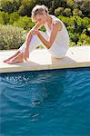 Femme assise au bord de la piscine et souriant