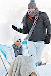 Jeune homme sur le point de lancer la boule de neige à la femme au repos