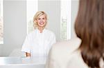 Female nurse looking at a woman and smiling