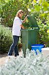 Woman looking into recycling bin
