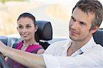 Couple driving a convertible car