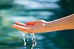 Close-up of a man's hand touching the water of the swimming pool