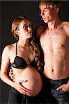 pregnant woman and her man on black background