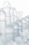 glass chess pieces are standing on board, cut out from white background