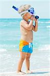 A cute little boy wearing a mask for diving background of the sea