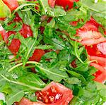 Healthy vegetarian Salad with rucola and  tomatoes on the white plate