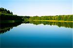 Blue sky with the sun over the water and scenic forests and rivers