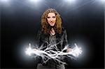 woman in rock and roll style with lightnings in hands on black background