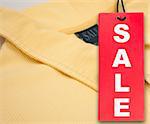 Hanging Red Sale Tag and Yellow Polo Shirt