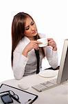 attractive woman with a cup of coffee sitting at the computer