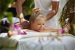 Young beautiful blonde caucasian woman gets massage and beauty treatment in luxury resort. Horizontal shape, side view