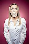 Young woman making a chewing gum bubble and looking right