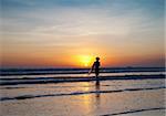 Surfer and waves at sunset in Bali, Indonesia