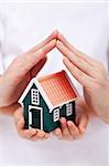 Protect your home - small house shielded with hands