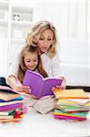 Reading a book with mom - little girl first spelling exercises