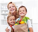 Happy family with the grocery bag full of fresh vegetables - healthy life concept