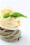 Italian pasta fettuccine nest  with basil