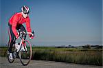 Man on road bike riding down open country road.