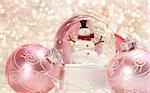 Snow globe with pink ornaments with sparkle background