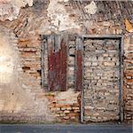 Old gungy wall with immured window and doors