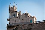 Fantastic castle on a rock: Swallow's Nest Castle tower, Crimea, Ukraine, with blue sky and sea on background