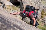 climber while climbing a vertical rock wall