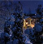 Illuminated house on snowy Christmas winter evening blue moment