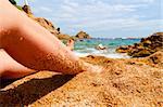female legs on beach at sunny day