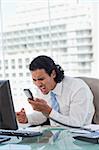 Portrait of a angry businessman shouting at his handset in his office