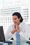 Portrait of a businessman thinking while using a computer in his office