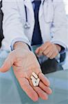 Portrait of a hand showing pills in an office