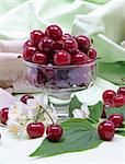 Sweet cherry in glass bowl with flower on linen fabric