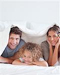 Smiling family lying in bed together