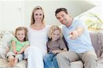 Family watching television together on the sofa