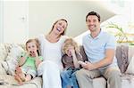 Family laughing on the sofa together