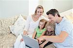 Family together on the couch with laptop