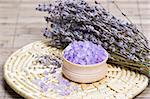 Aromatic bath salt and dry lavender flowers on bamboo mat shallow DOF