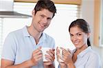 Happy couple drinking coffee in their kitchen