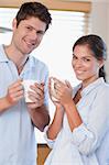 Portrait of a couple drinking coffee in their kitchen