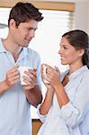 Portrait of a happy couple drinking coffee in their kitchen