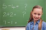 Cute schoolgirl posing in front of a blackboard