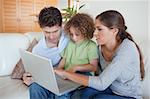 Young family using a notebook in their living room