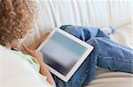 Back view boy using a tablet computer in a living room