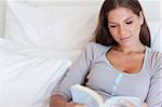 Woman reading a book in her bedroom