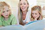 Mother reading magazine together with her children