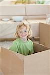 Little boy hiding in cardboard box
