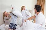 Playful family having a pillow fight together in the bedroom
