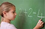 Schoolgirl writing a number on a blackboard