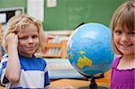 Pupils posing in front of a globe in a classroom